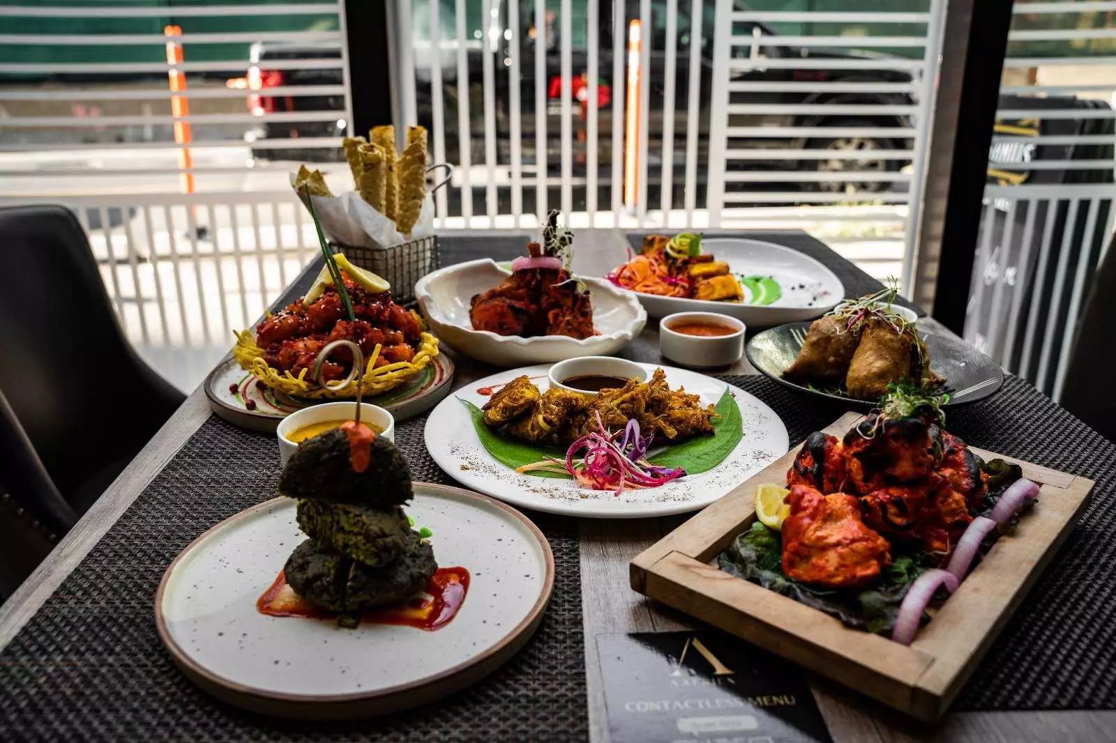 A window table set with fresh Indian dishes at Aafrien