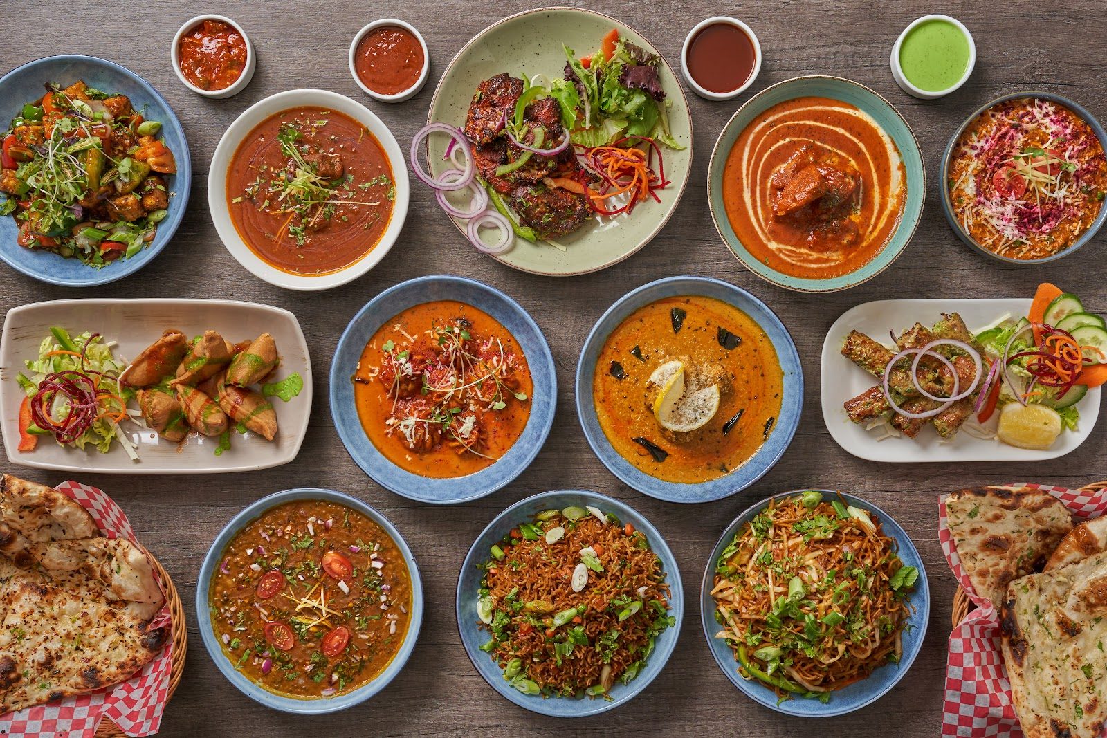 A full spread of Indian dishes, curries, tandoori, biryani and naan, at Aafrien Indian Restaurant, Toronto